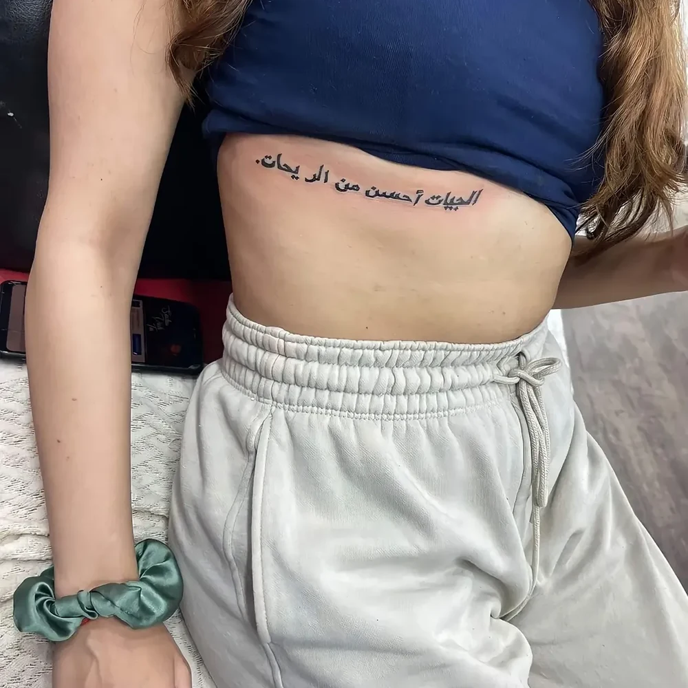 Close-up of an Arabic lettering rib tattoo by Sid Ink Tattoo, New Delhi