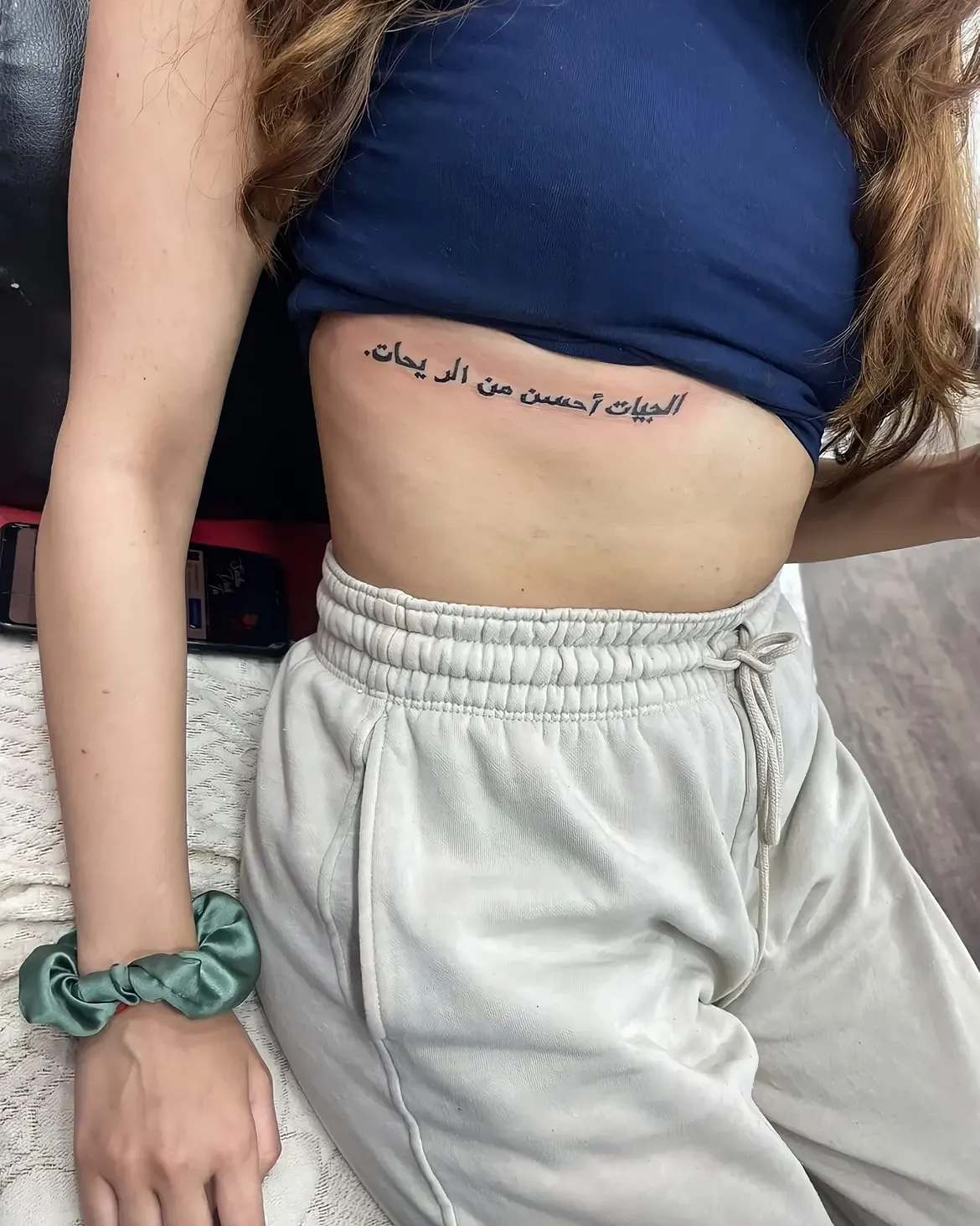 Black ink Arabic script tattoo along the ribs, tattooed at Sid Ink Tattoo Sarojini Nagar