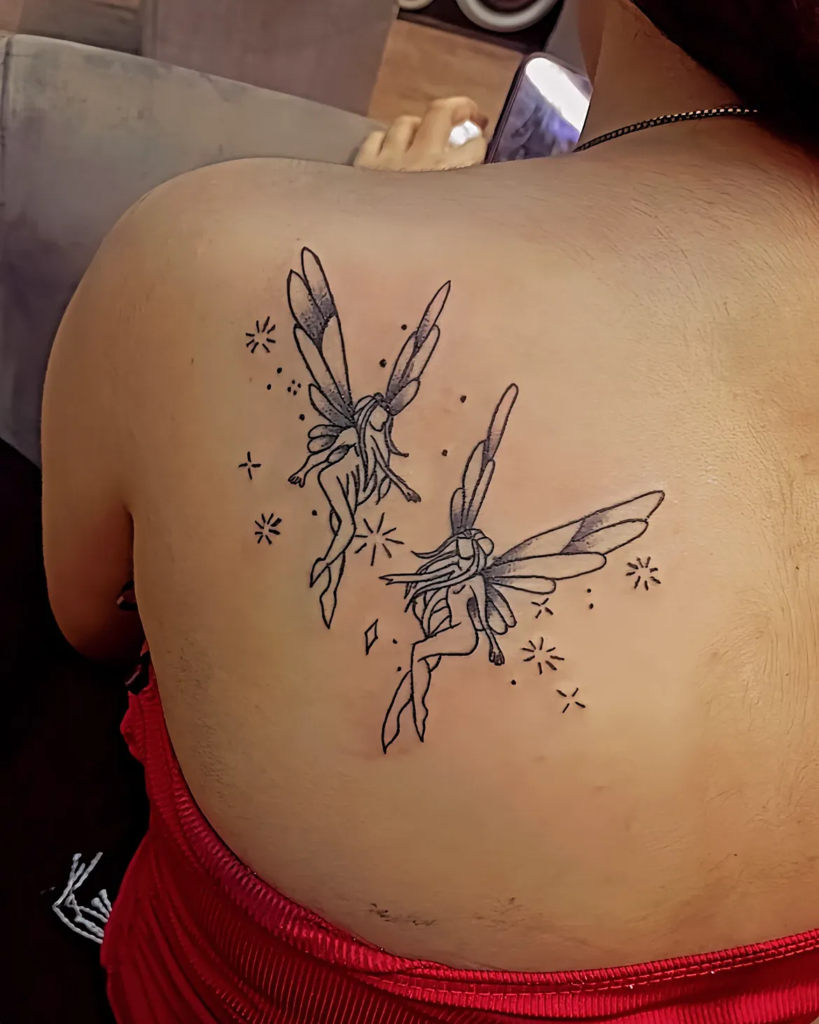 Fine line black ink fairy tattoo on the shoulder blade by Sid Ink Tattoo in Sarojini Nagar, New Delhi